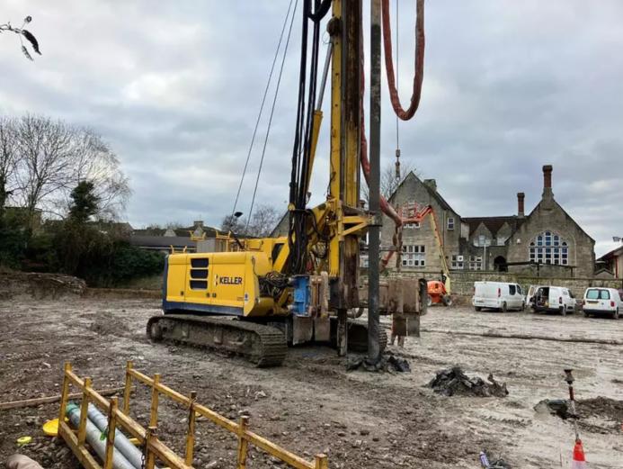 A yellow drilling rig on a constreuction site