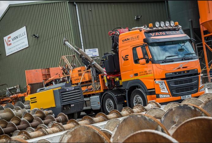 An orange HGV carrying an orange piling rig