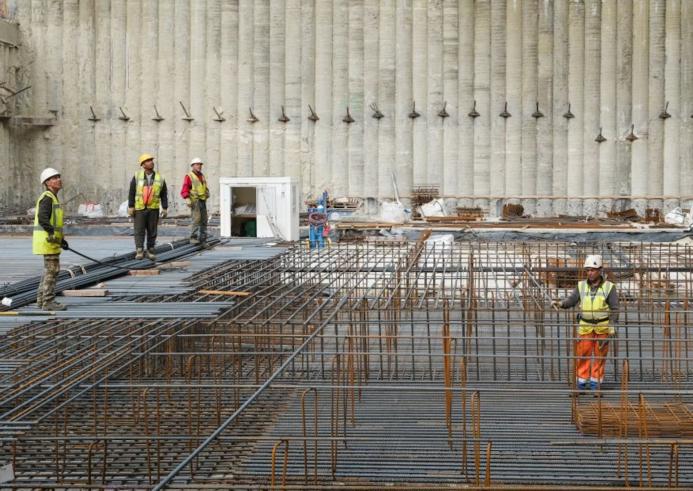 Men standing in a foundation pit during construction of a new building