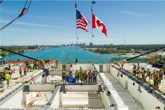 Construction workers on a bridge deck with the US and Canadian flags