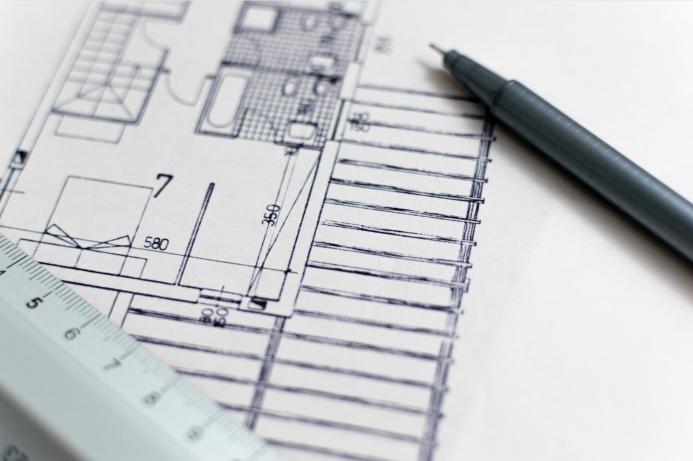 A black pen and a plan of a house with a white ruler