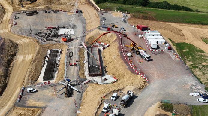 An aerial photo of a construction site with a red concrete pump