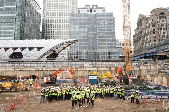 A large group of people wearing PPE in an urban construction site