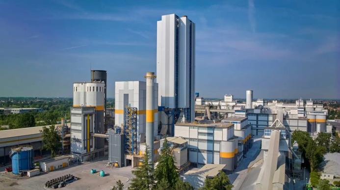 A white, grey and yellow cement plant against a blue sky