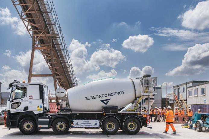 A white cement mixer and men in orange PPE