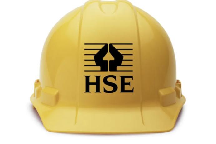 A yellow hard hat with the HSE logo in black on its front