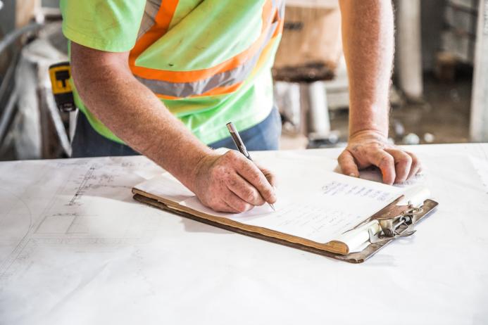 A construction worker looking at plans
