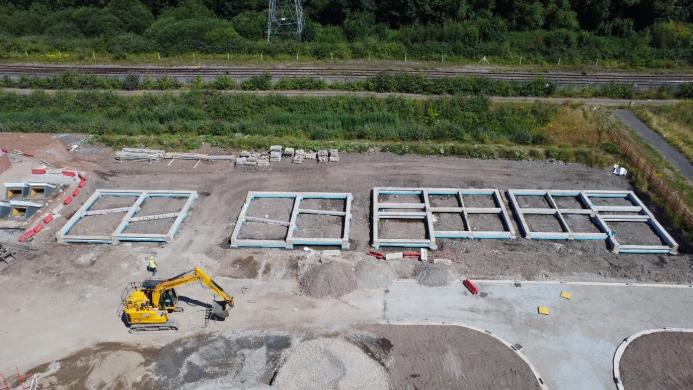 An aerial view of a construction site showing the foundations of several houses under construction.