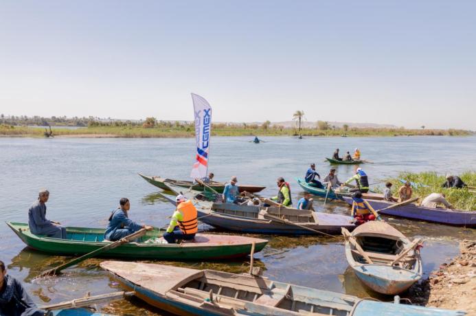People in small boats help clear the River Nile as part of the VeryNile environmental initiative
