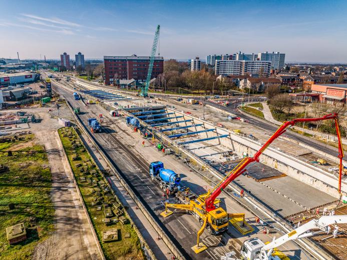 An aerial view of Ashcourt Concrete's 1,200m³ concrete pour for the A63 underpass project in Hull, showing a blue crawler crane and a yellow and red concrete pump.