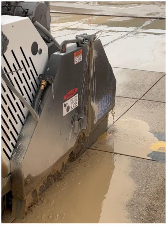 A diamond bladed saw cutting concrete paving slabs.