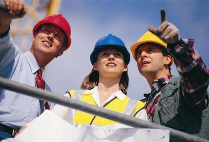 Three people in PPE. One in a red hard hat, one in blue and one in yellow.