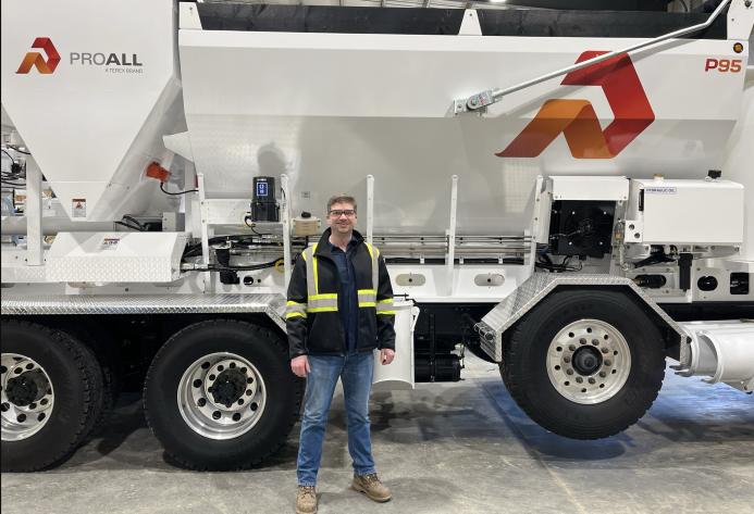 Derrick Murias, the new General Manager at ProAll, stand in front of a ProAll mixer.