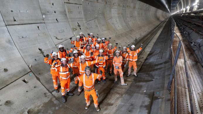 A group of construction workers gather in a tunnel to celebrate the completion of a 5 mile long tunnel under London as part of HS2