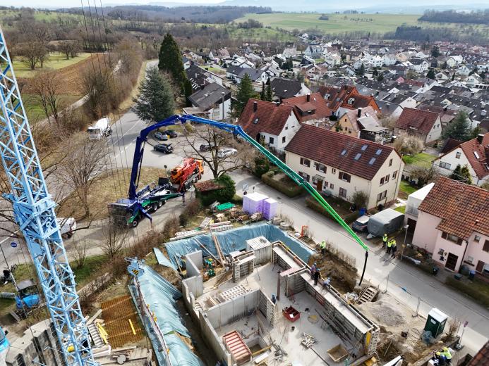 An aerial view of the new Volvo Trucks and Putzmeister fully electric alternative for pumping concrete in action on a construction site. 