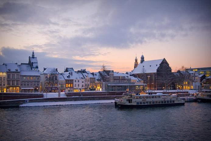 Sunset over Maastricht's docks, with a boat on the water.