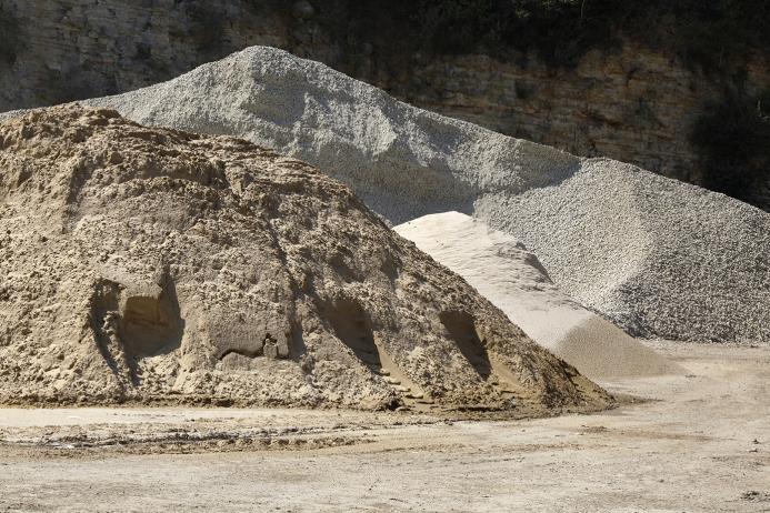 Two piles of aggregate on a quarry floor