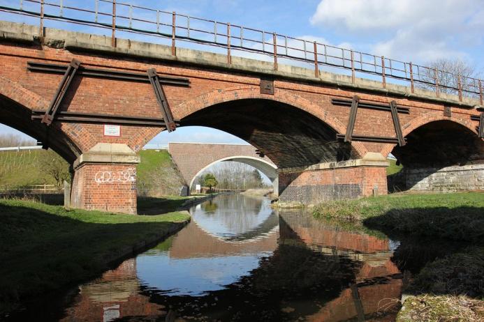 The original 18thC bridge over the historic Chesterfield Canal with the masonry-clad arch bridge seen through the middle arch. Image: ABM Precast Solutions.