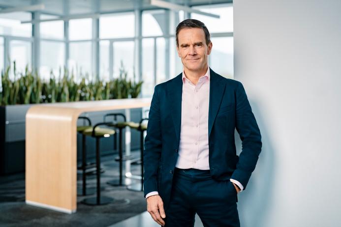 Dr Dominik von Achten, in dark suit and open neck shirt, standing in an empty office, has been elected the new president of GCCA, is chairman of the managing board at Heidelberg Materials
