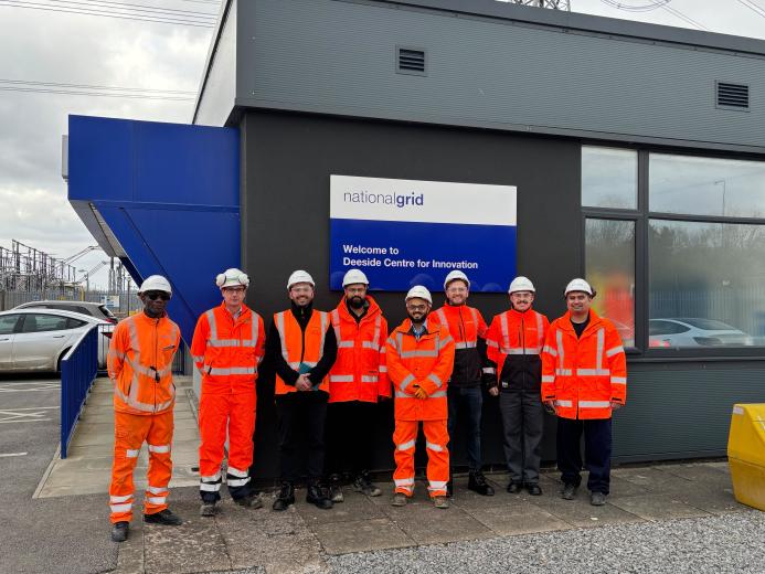 The Hyperion Robotics and National Grid teams, all in orange PPE, stand outside the Deeside Centre for Innovation, National Grid’s advanced testing facility in North Wales.