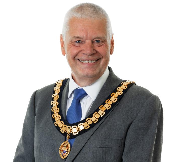 A photo of Paul Gandy, president, CIOB, wearing a grey suit, white shirt, blue tie and ceremonial chain.