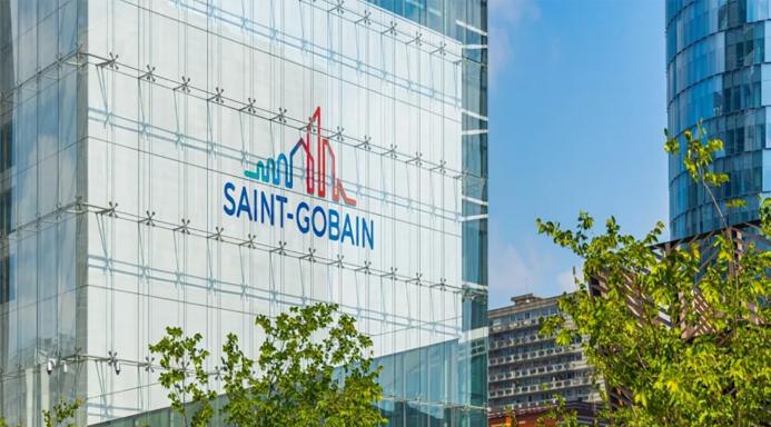 The blue and red Saint-Gobain logo on the side of a glass paneled, high-rise building.