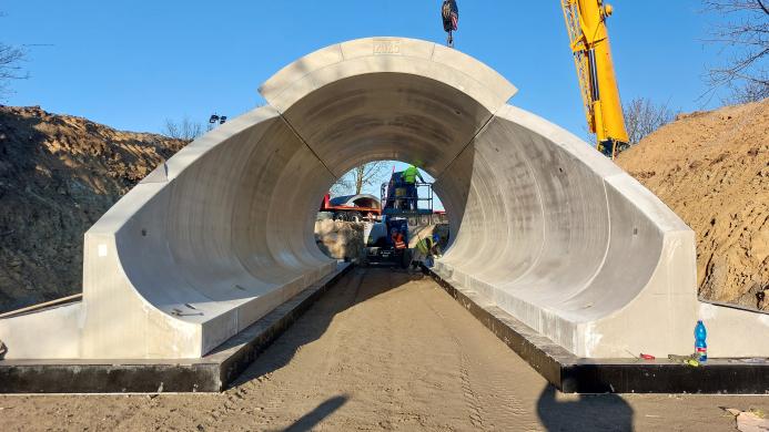Precast concrete bridge elements are assembled