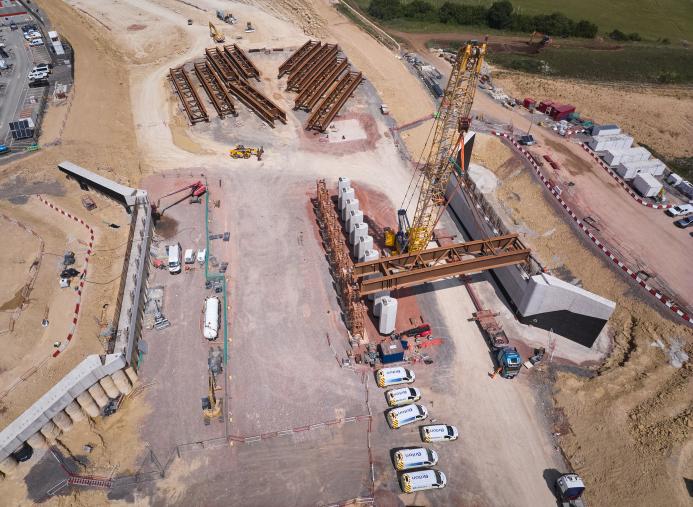 A yellow crane lifts beams into place for the Gloucestershire Way bridge, which will span the new A417 Missing Link and eight lanes of traffic