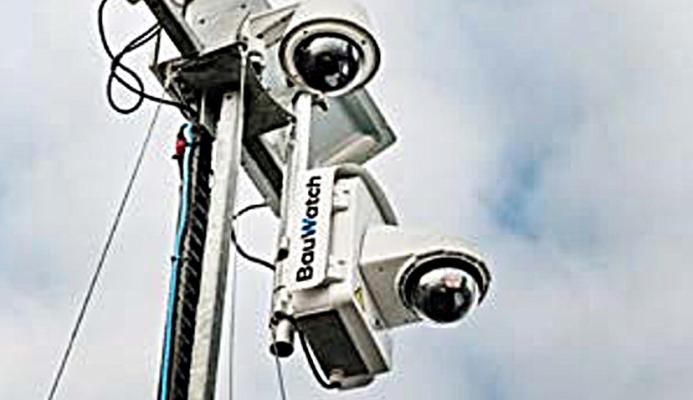 A close-up view looking up at two solar powered CCTV cameras mounted on a pole.
