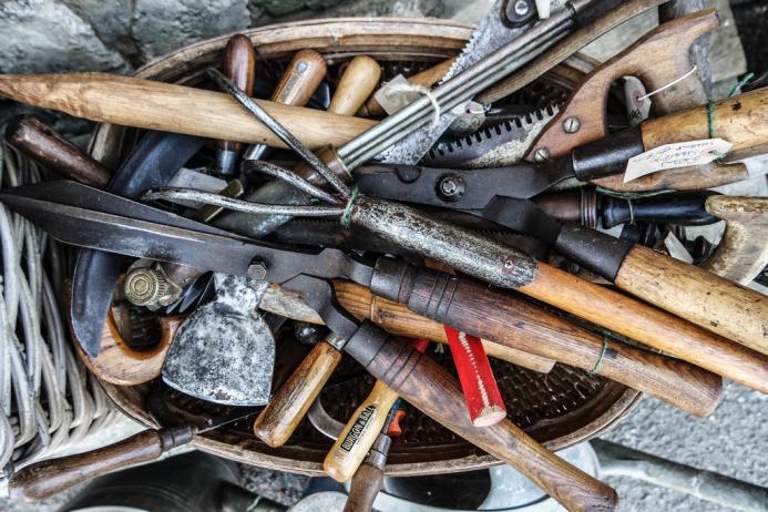 A bag of old hand tools with wooden handles
