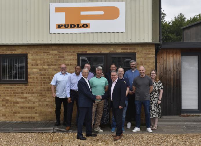 Malcolm Thornton and Scott Wilson (shaking hands) pictured with the PUDLO team outside their office following the deal to buy the company.