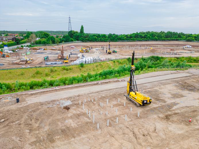 A yellow foundation rig prepares to start work at a large housing project in St Helens.