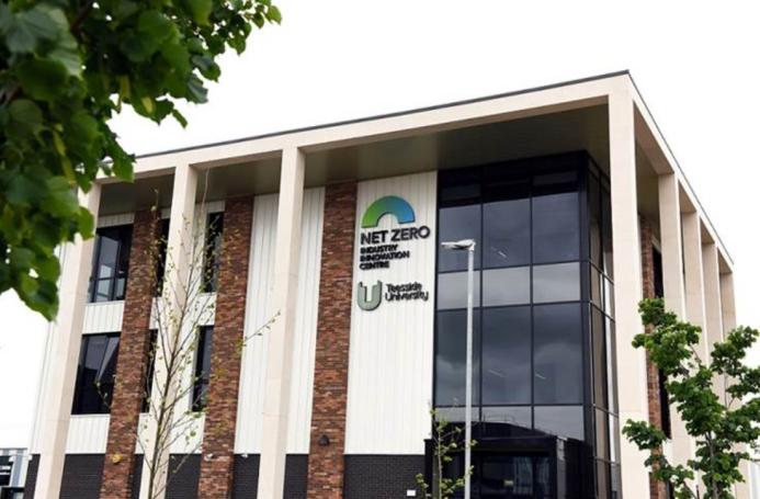 An external view of Teeside University’s Net Zero Industry Innovation Centre (NZIIC), a multi-storey building with a glass, red brick and white render facade.