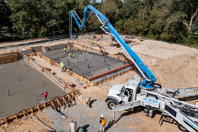 A concrete pump places concrete during construction of foundations