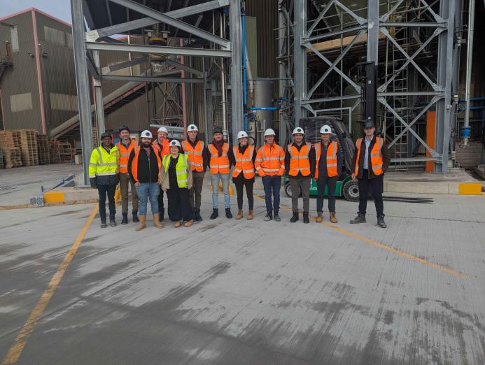 A group of people in yellow and orange PPE from Material Evolution, CRH, CRH Ventures & Tarmac at the Mevo A1 Production Facility in Llay, Wales
