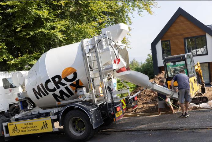 Two men unload concrete from one of Micromix’s agile trucks, which can deliver concrete loads from 0.5 to 4 m³, now with added convenience via online ordering.