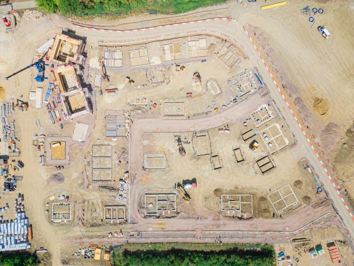 A drone shot of a new housing estate under construction showing the foundations of the new houses