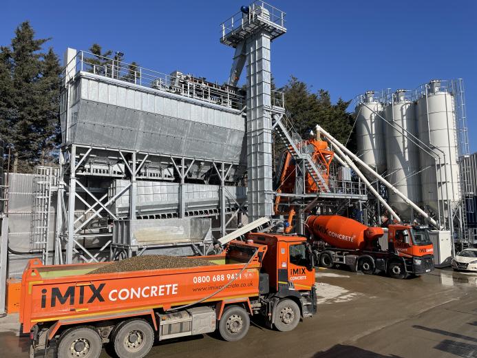 An orange tipper truck and orange cement mixer wait by the new iMIX plant in Essex is MCT Italy’s first UK ready-mix installation, built for high-volume output and flexibility.