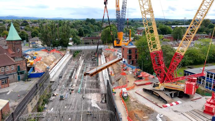 The first of the new steel and concrete beams is lifted into place across the West Coast Main Line during the Greek Street bridge replacement.