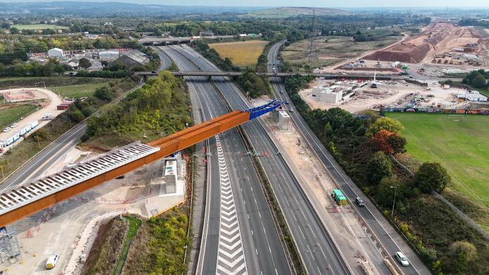 An aerial view of The HS2 viaduct East Deck being slid into place over the M6, supported by four pairs of reinforced concrete piers.