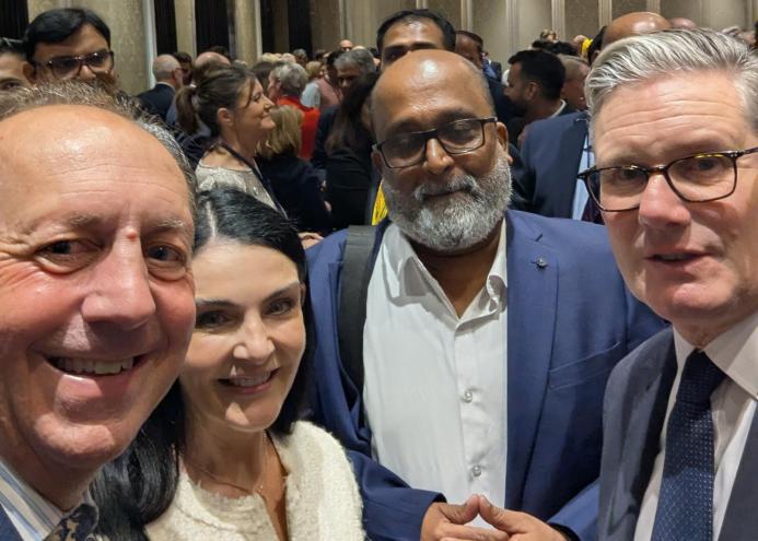 Four people look into the camera to take a selfie