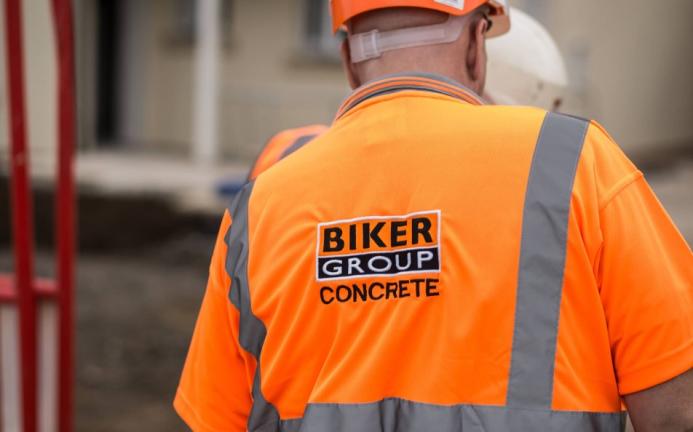 A construction worker in Biker Group branded orange PPE and hard hat