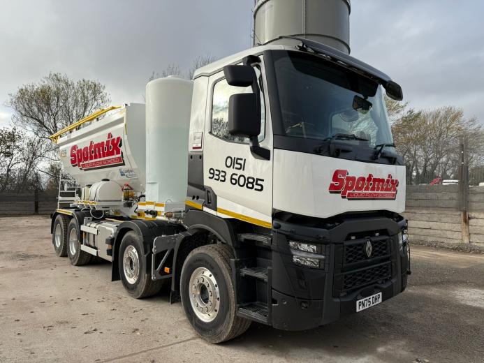 A white screed truck with red decals