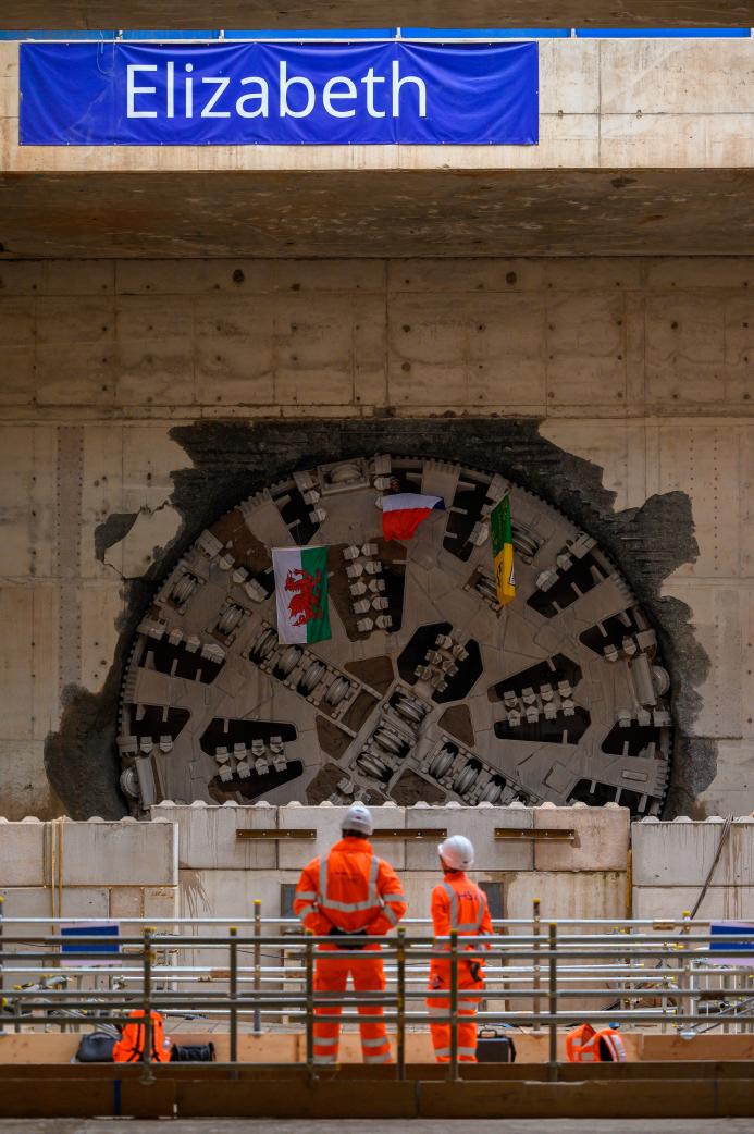Two men wearing orange PPE look at The cutterhead of TBM Elizabeth visible through the headwall at Washwood Heath following her 3.5 mile drive Oct 2025