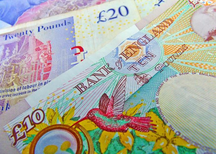 A close up of various UK paper money, including a £20 and £10 note.