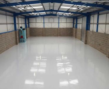 An interior view of an empty warehouse with an epoxy resin floor