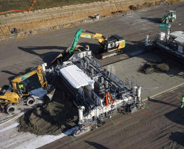 An aerial view of some men and machines repairing a concrete road