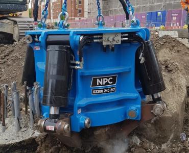 A close up of a blue pile cropper cutting a concrete pile