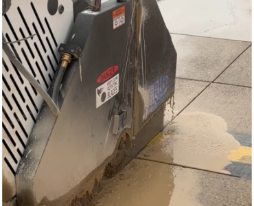 A diamond bladed saw cutting concrete paving slabs.