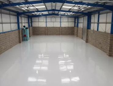 An interior view of an empty warehouse with an epoxy resin floor
